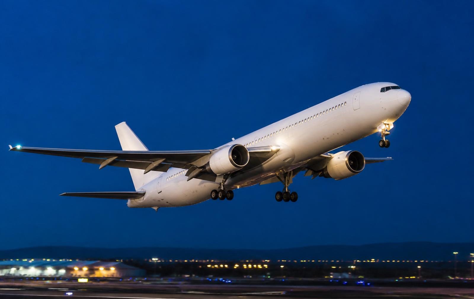 Avión comercial despegando al anochecer